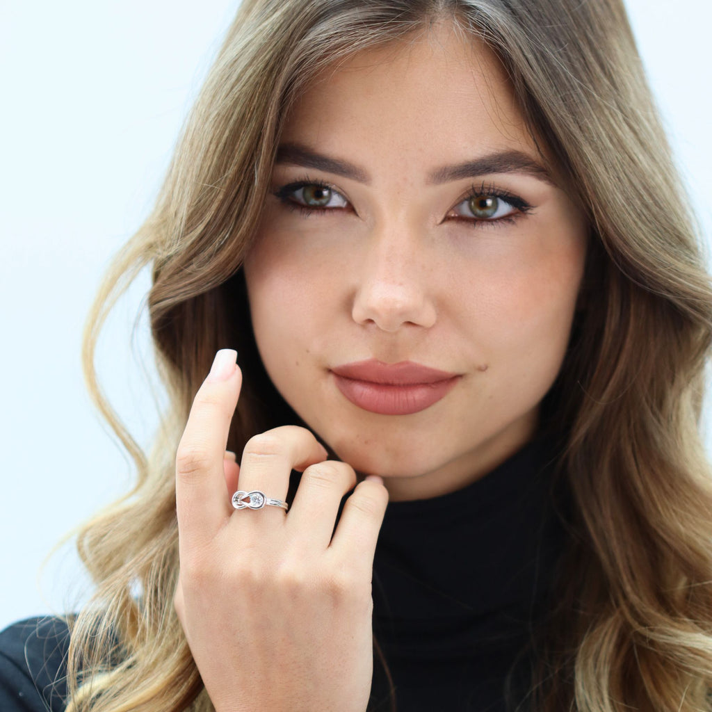 Side view of white gold ring showing infinity symbol and adjustable band opening